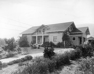 Three people in front of a house thumbnail
