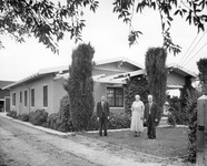 Three people in front of a house thumbnail