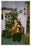 Michele Serros and a cat in front of a Christmas tree thumbnail