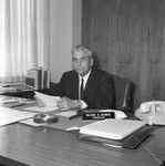 Chancellor Glenn S. Dumke sits at his desk. thumbnail