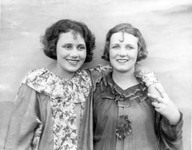 Two women in costume smiling. thumbnail