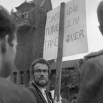 Man stands with protest sign on front of Tower Hall thumbnail