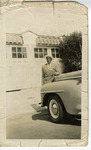 African American man in driveway, leaning against car. thumbnail