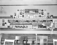 Child holding a pointer beside various classroom displays thumbnail