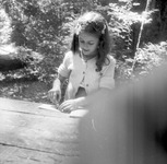 Young girl working at a table in the woods thumbnail
