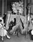 Billy DeFrank wearing a high feather headdress. thumbnail