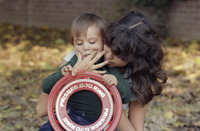 Adam Watkins Sitting in Autumn Leaves Pile at Home thumbnail