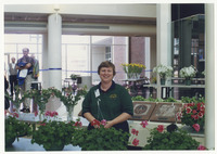 [Woman standing in an aisle of flowers] thumbnail