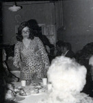 Woman standing at a table thumbnail