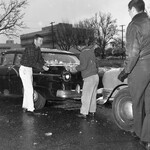 Three men scrape snow off a car thumbnail