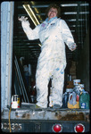 [Student gesturing aboard a large truck, surrounded by paint containers] thumbnail