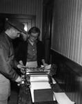 Two people using a mimeograph thumbnail