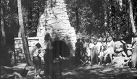 Group of women and teenage girls near a large outdoor stone hearth thumbnail