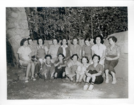 Group portrait of teenage girls outside by a large stone hearth thumbnail