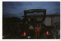 Michele Serros sitting in the trunk of a car thumbnail
