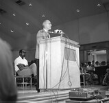 Robert D. Clark gives a speech from a podium. thumbnail