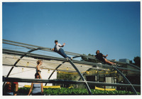 [People laying on top of unfinished greenhouse frame] thumbnail
