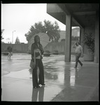 [Student in rain by University Union], 1976 thumbnail