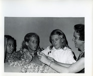 Mrs. Mary Mahle helps three girls make leis thumbnail
